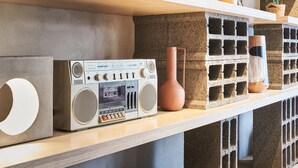 Een plank met een oude radio, een vaas en een plank met een baksteenpatroon.
