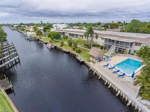 A waterfront hotel with a swimming pool, dock, and a river.