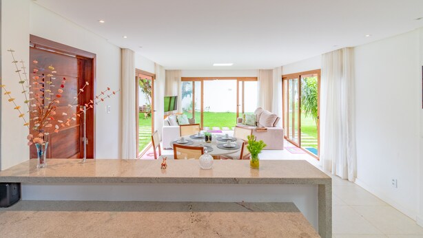 Ein modernes Interieur mit Essbereich, einer Sofagarnitur und Blick ins Freie.