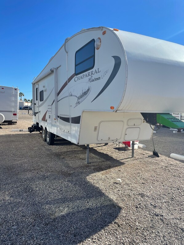 Un camping-car blanc sur lequel on peut voir le logo « Chaparral Coachmen Lite » sur le côté.