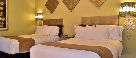 A hotel room with two beds, a painting, and wall-mounted lamps.