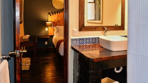 A hotel bathroom with a wooden vanity, a white sink, and a mirror above the sink. - Hotel Mesones 49 (San Miguel de Allende)