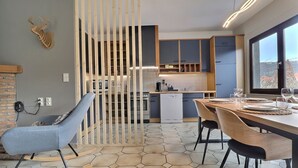 Eine moderne Küche mit Essbereich, einem Schaukelstuhl und Blick durch ein Fenster.