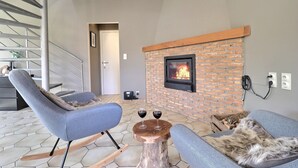 Ein modernes Wohnzimmer mit Kamin, zwei Sofas und einer Treppe.