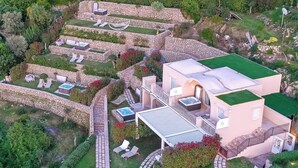 Eine luxuriöse Villa mit mehreren Terrassen, Sitzbereichen im Freien und einem Swimmingpool.