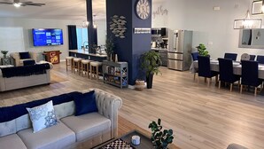 A modern living room with a sofa, coffee table, and a TV displaying a streaming service. - LARGE MODERN 4 BEDROOM HOME. VERY PRIVATE w HOT TUB & 3 acres!  (Crystal River)