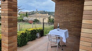 A patio with a table and chairs, a metal grill, and a view of a hill with buildings. - House in a quiet area with views of the old town of Pals (Pals)