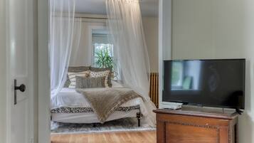 Un dormitorio con cama, televisor y un armario de madera.