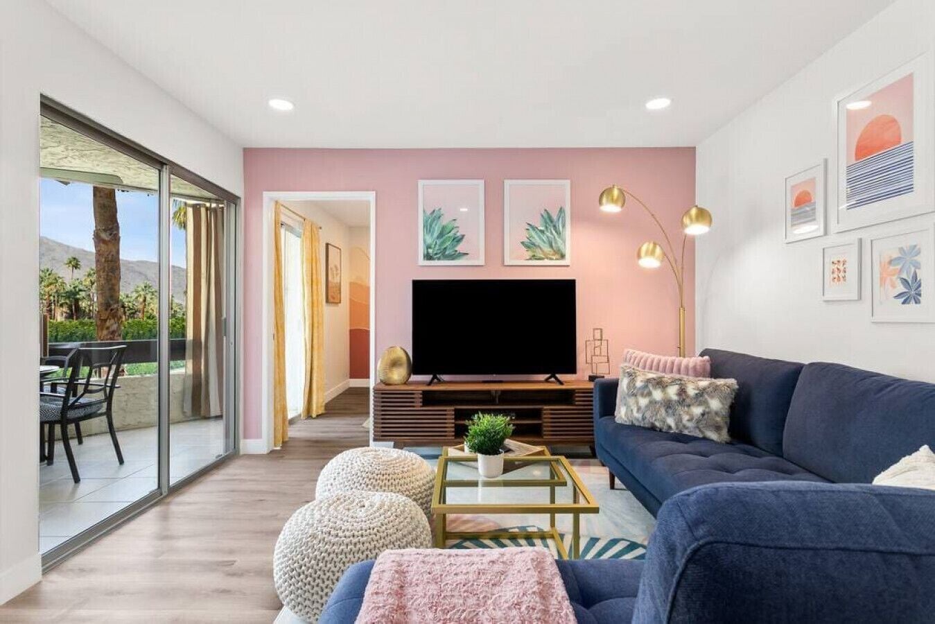 Ein modernes Wohnzimmer mit Fernseher, Sofa, Couchtisch und dekorativen Kissen.