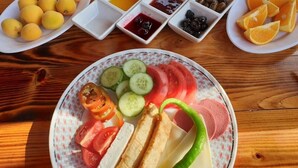 A wooden table with various food items and condiments. - Karabibik Bungalow (Demre)