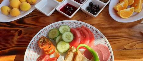 A wooden table with various food items and condiments.