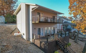 Une maison à deux étages avec un balcon à l’étage supérieur, une véranda et un escalier menant à l’étage.