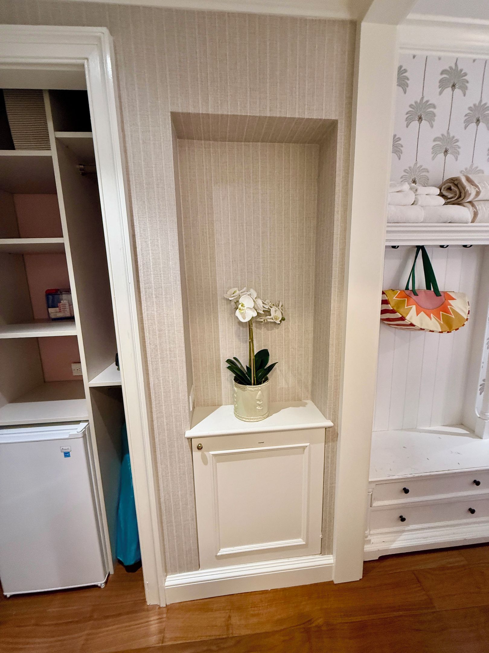 A small white cabinet with a single orchid plant.