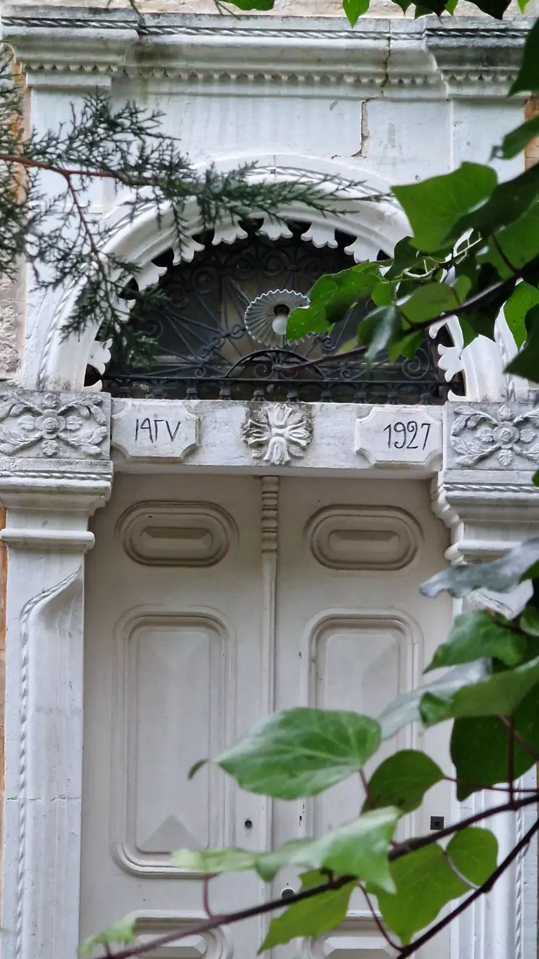 A white door with the inscription "ATV 1927" and decorative elements.