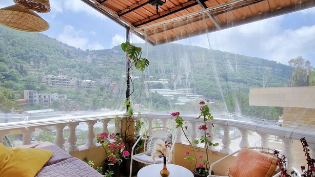 A balcony with a bed, chairs, and potted plants. - 19th Century Charming Ottoman Historical House   (Mount Lebanon Governorate)