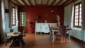 A dining room with a wooden table and chairs, a white cabinet, and a red wall. - 3 Bedroom Private vacation home in ROSAY SUR LIEURE (ROSAY SUR LIEURE)