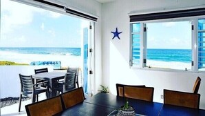 A dining area with a view of the beach and ocean. - breathtaking sea view Beach FRONT very PRIVATE and quiet SOLAR POWERED (Arecibo)