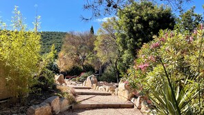 A garden with a stone pathway, rocks, and various plants. - Große Villa für max. 12 Personen mit Privatpool und schönem Garten, Meerblick (La Croix Valmer)