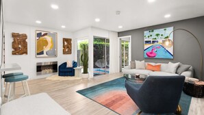 A modern living room with a sofa, coffee table, and artwork on the walls. - Newly renovated, vibrant and chic Biltmore condo (Palm Springs)