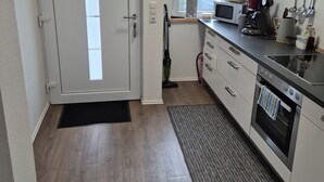 Una cocina compacta con microondas, cafetera y horno.