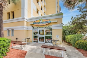 Situated in a modern setting, the Birch Lane Coffee Company offers outdoor seating with white chairs and tables.