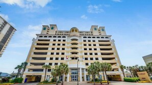 A multi-story hotel with a central entrance, multiple balconies, and a prominent "Camelot" sign. - New Penthouse-Oceanfront, Heated Pools, TOP Floor (Myrtle Beach)