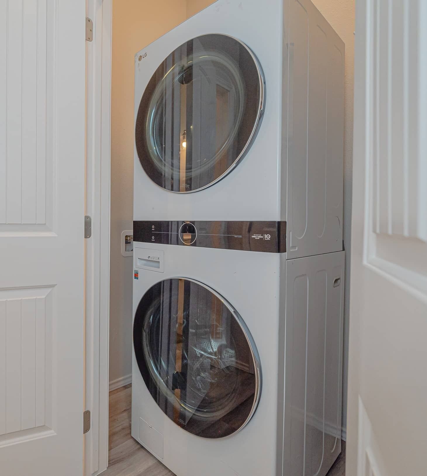 A stacked washer and dryer unit in a hallway.