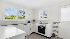 Enjoy cooking in this well-equipped kitchen with a stainless steel sink, oven, and kettle.