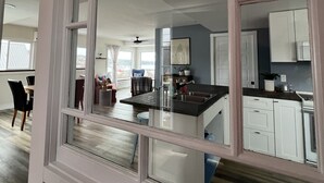 A modern kitchen with white cabinetry and a central island. - Fantastic Beach & Ocean Views (Grand Manan)