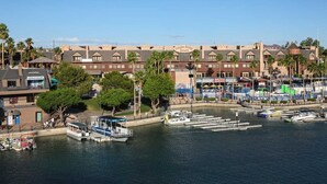 Un puerto deportivo con barcos amarrados, un edificio con un letrero que dice "London Bridge Resort", y una vista al frente del agua.