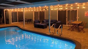 Ein Poolbereich im Innenbereich mit Pool, Liegestühlen und einem Tisch.