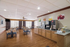 A spacious room with a kitchen area, wooden flooring, and a ceiling fan. - Alice Western Inn (Alice)
