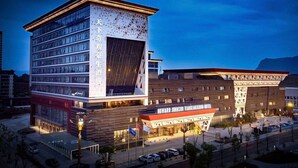 A hotel with a modern design, featuring a prominent entrance and multiple floors. - Howard Johnson by Wyndham Tianxiaqiguan Hotel Xingwen (Yibin)