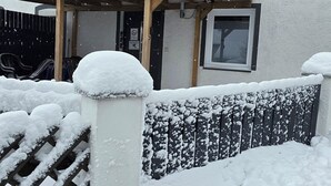 A house with a covered porch and a snow-covered fence. - W.I.L.A. 1 (Helmbrechts)