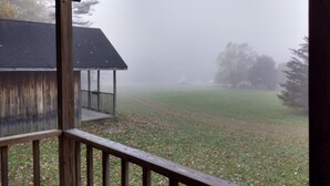 A wooden deck with a view of a building and a foggy landscape.