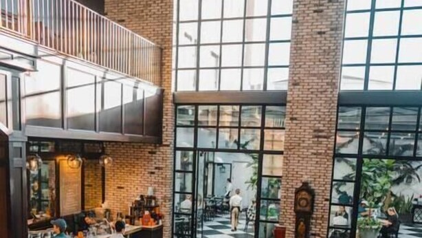 A spacious lobby with a high ceiling, a bar area, and seating arrangements.