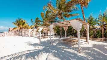 Am Strand, weißer Sandstrand, Strandtücher, Strandbar