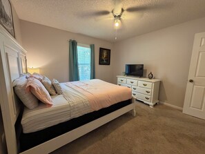 A bedroom with a bed, dresser, television, and a ceiling fan. - Spacious Peaceful Home 3BR 2BA,Quiet Neighborhood (Valdosta)
