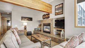 Una sala de estar moderna con chimenea, asientos cómodos y televisor.