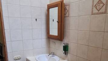 A small bathroom with a toilet, sink, and mirror.