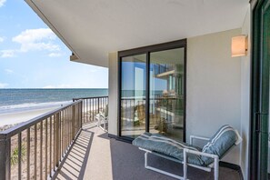 Enjoy the ocean view from this balcony with a comfortable bench.