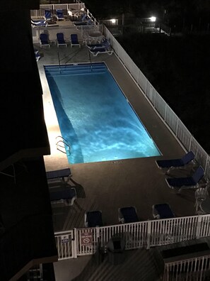 Relax by the pool with lounge chairs and tables nearby.