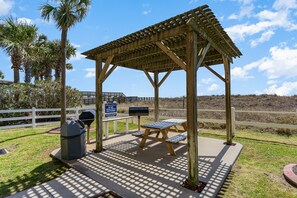 Sheltered by a sloped roof, this gazebo offers a shaded area for relaxation.