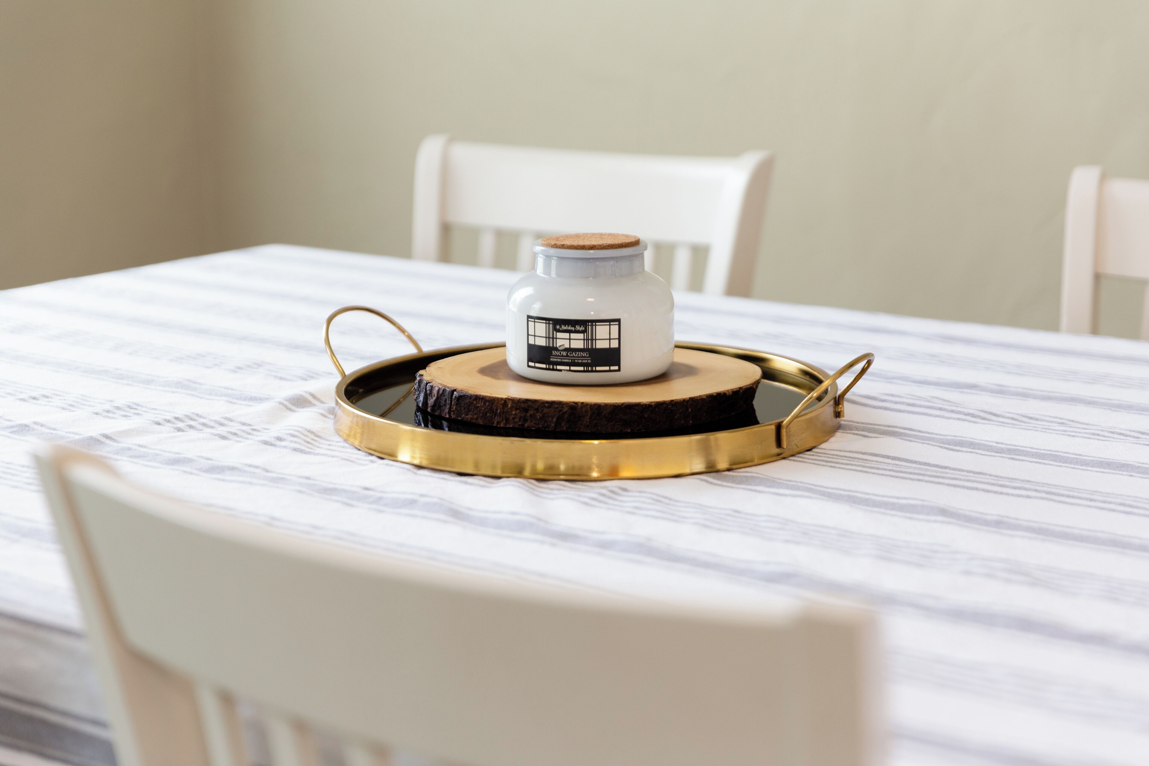 A table with a white tablecloth, a jar of honey, and a gold tray.