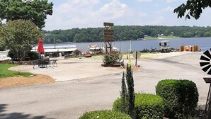 A lakeside parking area with a signpost, picnic tables, and a boat dock. - Birdsong Resort Marina Lakeside RV (Camden)
