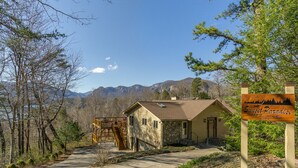 Eine Lodge mit Steinfassade, einer Holzterrasse und einer Bergkulisse im Hintergrund.