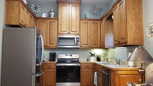Une cuisine dotée de meubles en bois, d’appareils électroménagers en acier inoxydable et d’objets décoratifs.