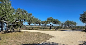 Stroll along the shaded path to a serene seating area surrounded by mature trees.