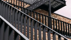 A staircase with black metal railings leading to a brick building. - Factory Hotel (Beveren)