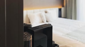 A hotel room with a bed, a bedside table, and a lamp. - Factory Hotel (Beveren)
